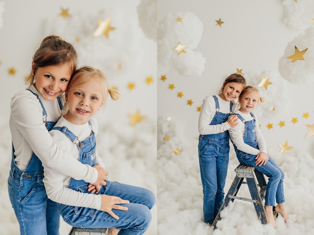 Two giggling sisters capture memories during a fun-filled cloud mini session in the studio.