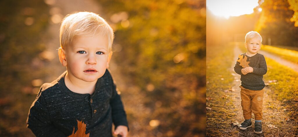 A young boy poses for a photo at sunset while holding a fall leaf