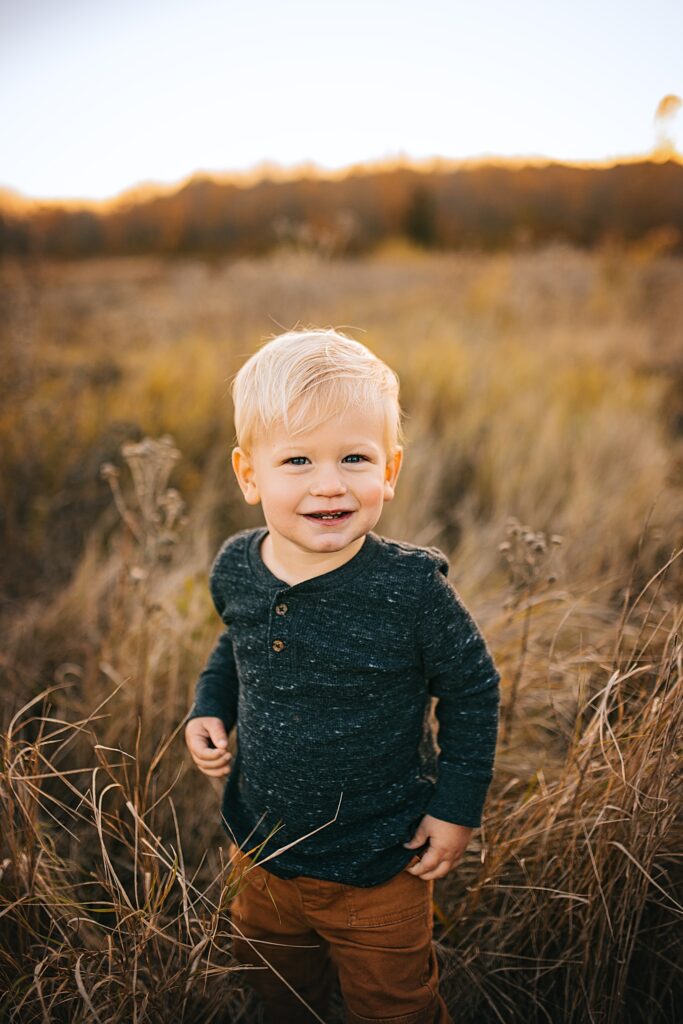 a young boy in a field at sunset