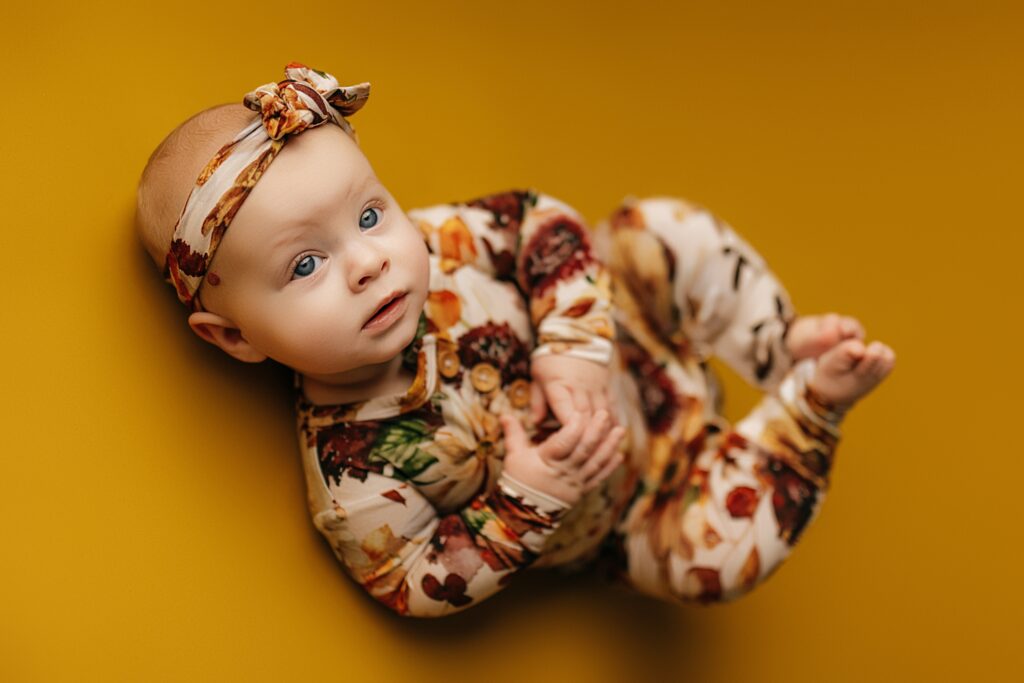 A six-month-old baby captured during a milestone photo session