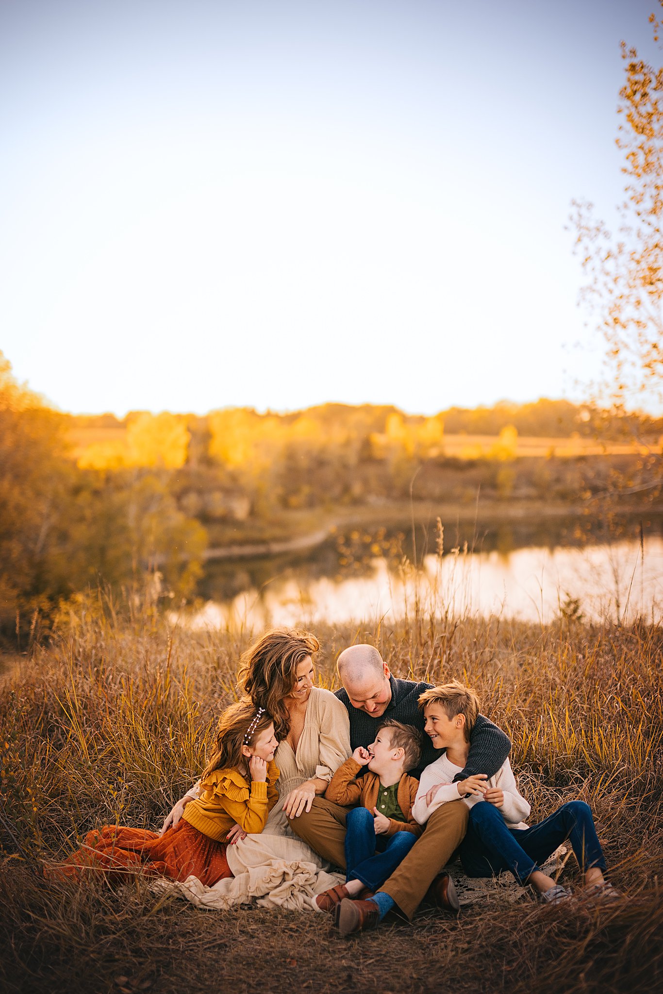A family shares a candid moment together at sunset on the edge of a quarry