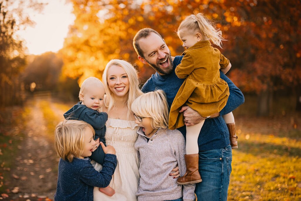 A family shares a joyful moment together among the beautiful fall colors.