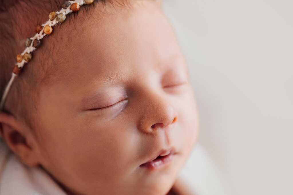 Close-up of a newborn's tiny facial features during an in-home session.