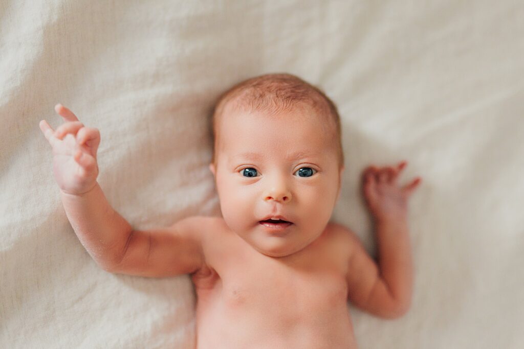 Close-up of a newborn's tiny hands and face during an in-home session.