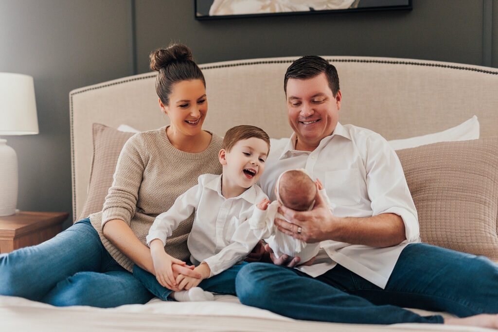 A family enjoys tender moments with their newborn in the comfort of their home.