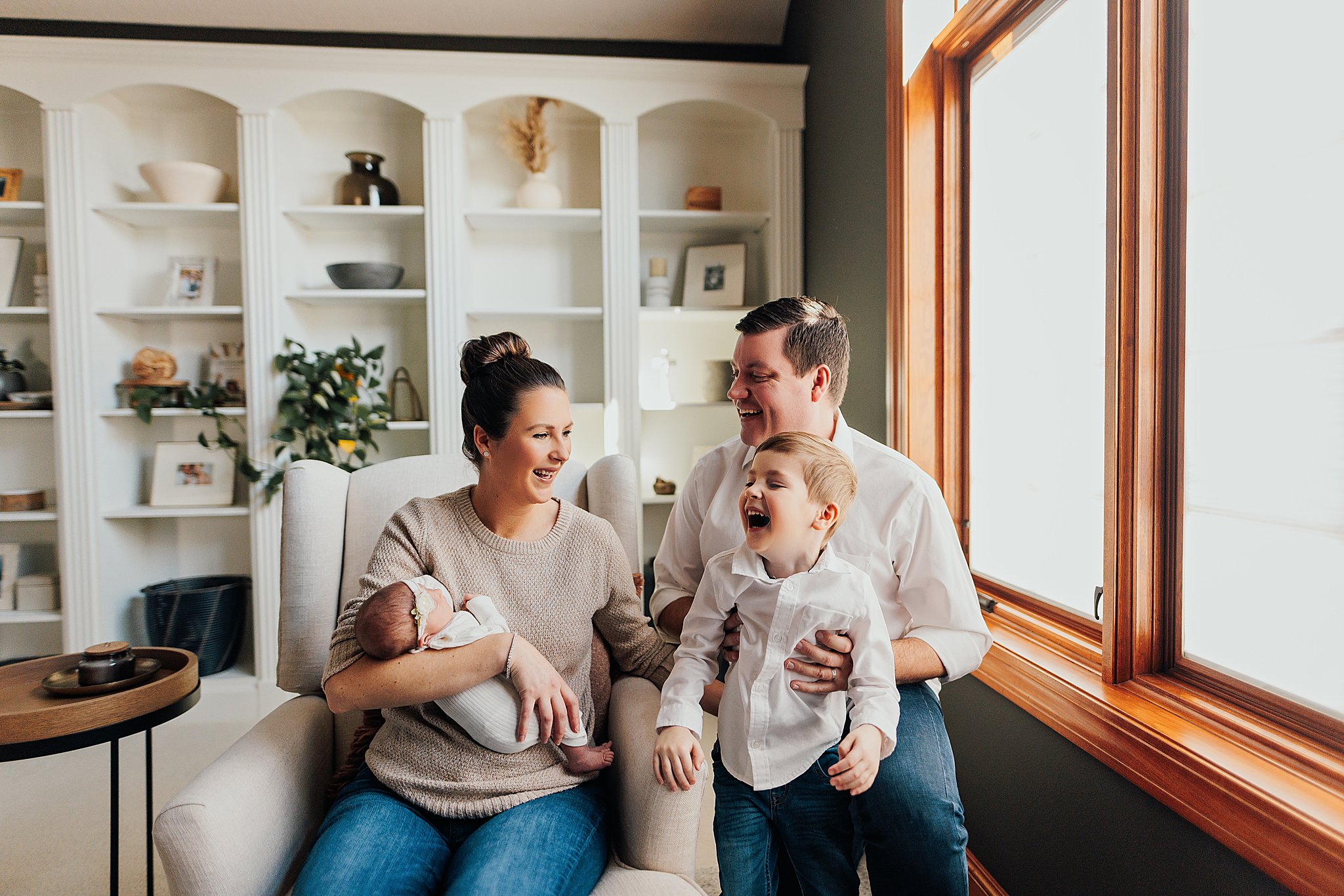 A family enjoys tender moments with their newborn in the comfort of their home