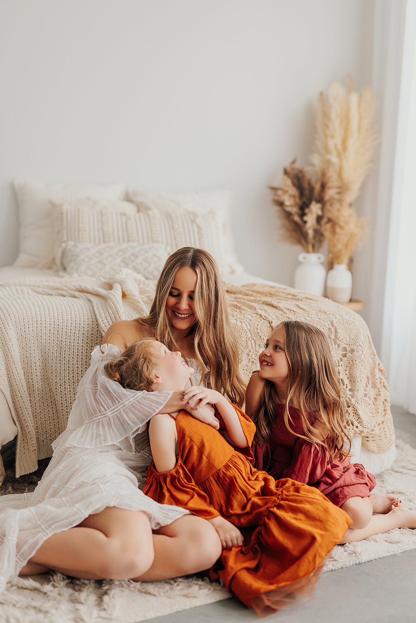 Mother and her two daughters sharing sweet moments during a Mommy and Me session in a Cedar Falls, Iowa studio