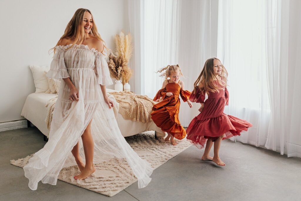 Mother and her two daughters sharing sweet moments during a Mommy and Me session in a Cedar Falls, Iowa studio