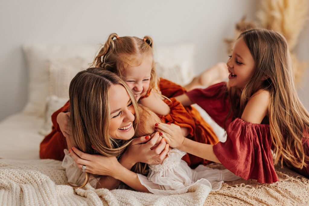 Tender moment between a mother and her daughters, with a mix of solo and sibling shots in a Cedar Falls, Iowa studio