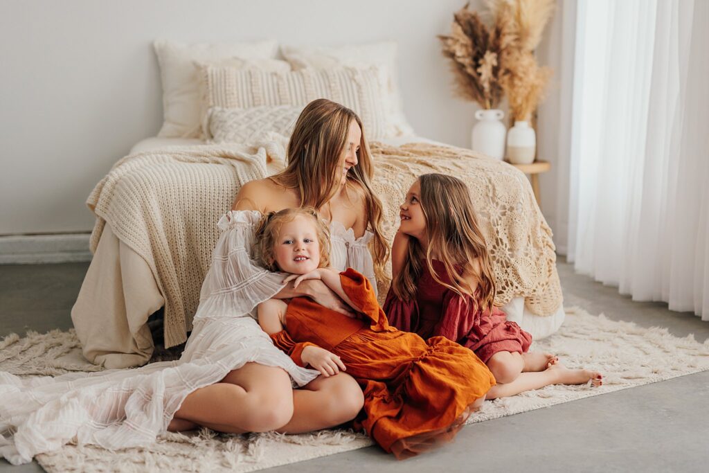 Tender moment between a mother and her daughters, with a mix of solo and sibling shots in a Cedar Falls, Iowa studio